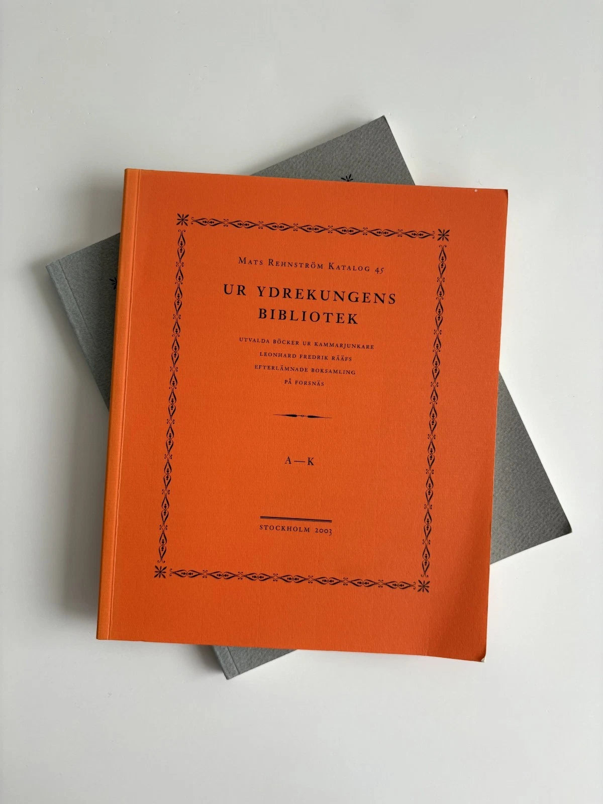 Orange book with black text on a gray surface