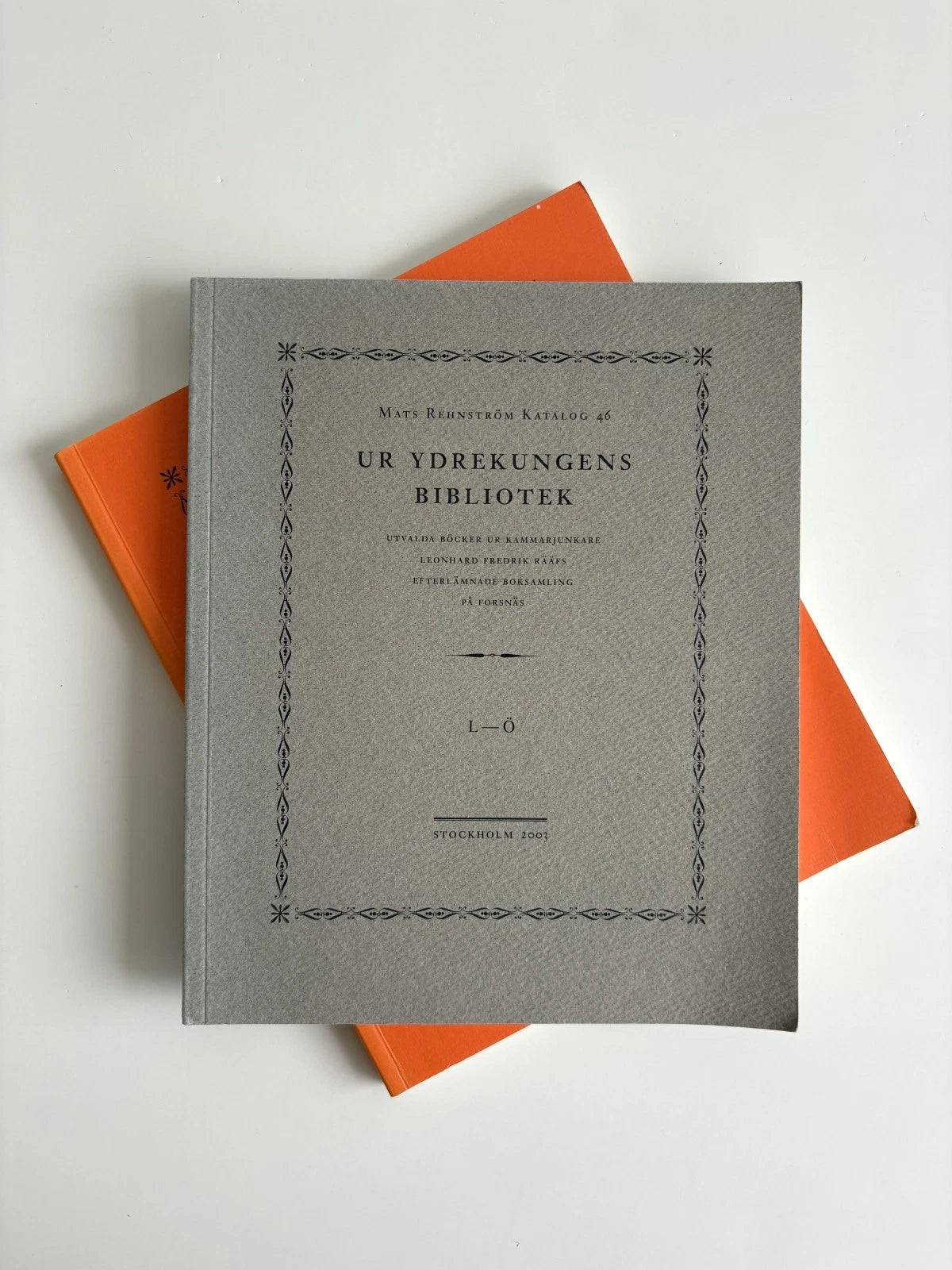 Gray book with decorative text on an orange background